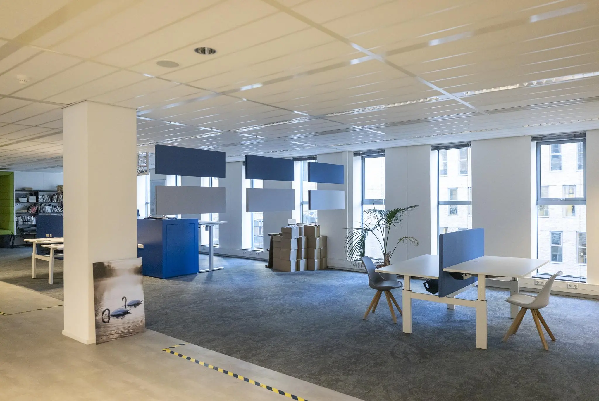 Kantoorruimte aan de Prinses Beatrixlaan met moderne werkplekken, grote ramen en stapels dozen bij het raam.